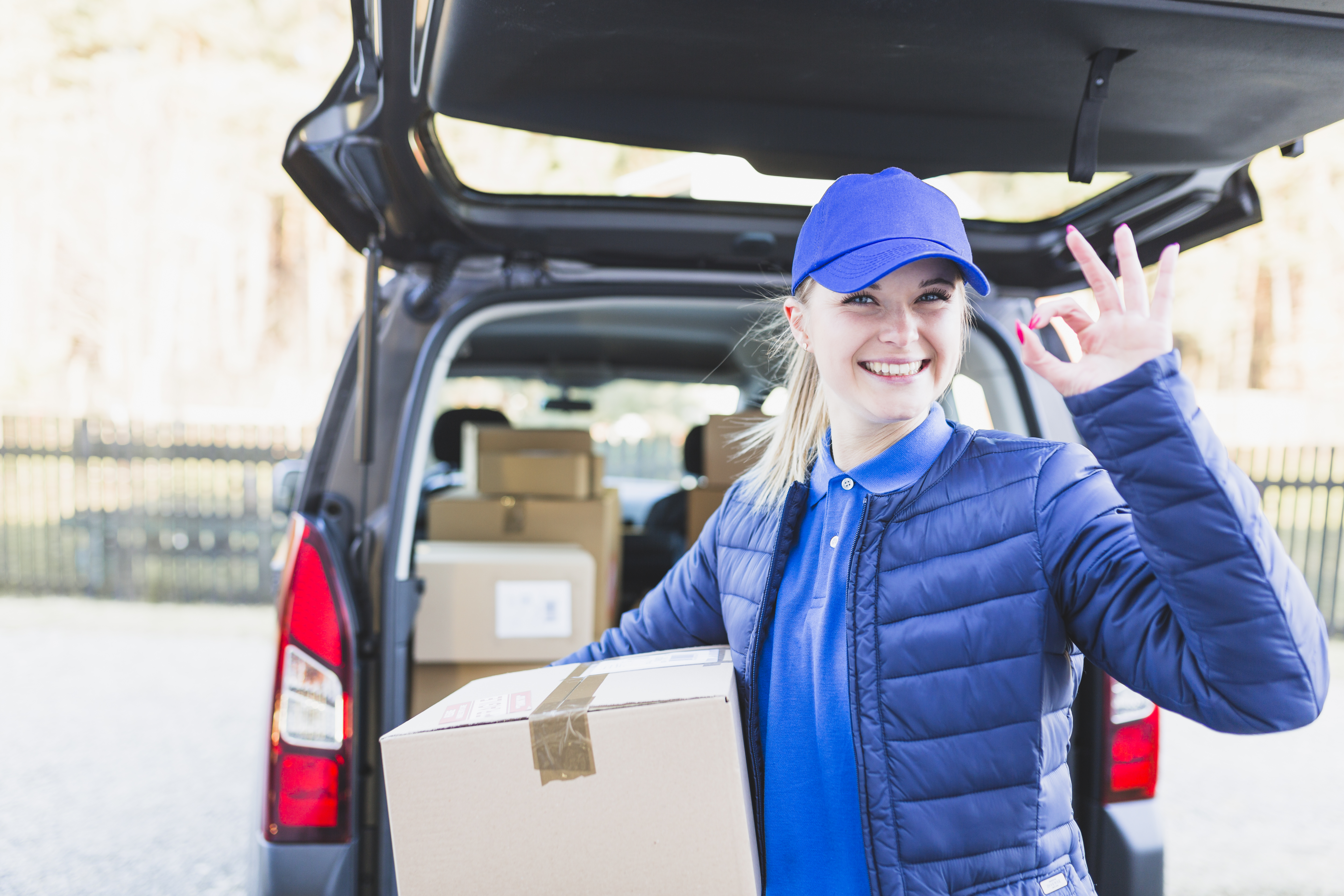 charming-courier-with-box-gesturing-camera